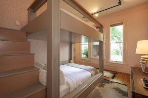 a bedroom with a bunk bed and a desk at Takeover at the Grand Maloney by Brightwild in Key West