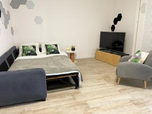 - une chambre avec un lit, une télévision et une chaise dans l'établissement Au cœur des Arènes - Parking privé, à Metz