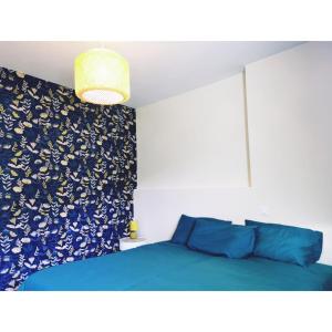a bedroom with a blue bed with a blue patterned wall at Chalet Coté Cour à 10 min de la Station in Oz