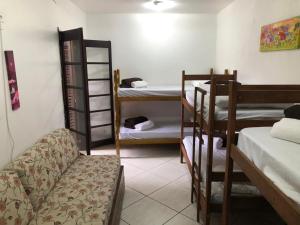 a room with several bunk beds and a couch at Espaço A Corrente in Embu