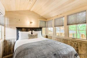 um quarto com uma cama num quarto com janelas em The Mulberry in Treehouse Grove at Norton Creek em Gatlinburg