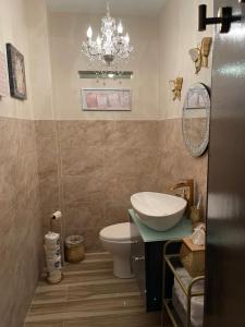 a bathroom with a sink and a toilet and a chandelier at The Balconies Studio, The Marilyn Suite & The Crystal Apartment at Casa of Essence in Old San Juan in San Juan