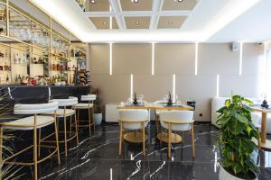 a restaurant with stools and a bar at Destiny Hotel & SPA in Tirana