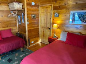 2 Betten in einem Zimmer mit Holzwänden in der Unterkunft Tahoma Meadows in Tahoma