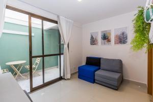 sala de estar con silla azul y ventana en Noroeste 10/11 Square, en Brasilia