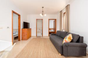 uma sala de estar com um sofá e uma televisão em Zala Hills Apartman - Batthyány Villapark em Zalacsány