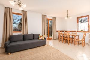 un soggiorno con divano e una sala da pranzo di Zala Hills Apartman - Batthyány Villapark a Zalacsány