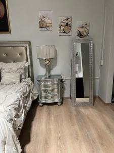 um quarto com uma cama, um espelho e um candeeiro em The Balconies Studio, The Marilyn Suite & The Crystal Apartment at Casa of Essence in Old San Juan em San Juan