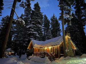 una cabaña de madera en la nieve por la noche en Tahoma Meadows en Tahoma