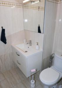 uma casa de banho com um lavatório, um WC e um espelho. em Chill and Work entre Paris et Disney em Neuilly-Plaisance
