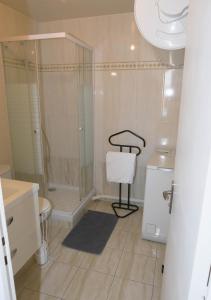 uma casa de banho com um chuveiro e uma cadeira. em Chill and Work entre Paris et Disney em Neuilly-Plaisance