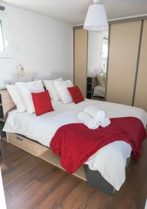 een slaapkamer met een groot bed met rode en witte kussens bij Chill and Work entre Paris et Disney in Neuilly-Plaisance