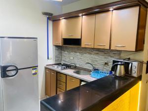 a kitchen with a refrigerator and a sink at Porto Sokhna Water Front For Familis in Ain Sokhna