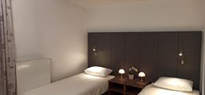 een slaapkamer met 2 bedden en 2 tafels met lampen bij OK studio & rooms Lipik in Lipik