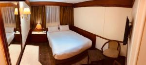 Dormitorio pequeño con cama blanca y lámpara en Prince Omar Nile Cruise - Luxor to Aswan, en Asuán