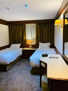 a hotel room with two beds and a desk at Prince Omar Nile Cruise - Luxor to Aswan in Aswan