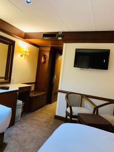 a hotel room with a bed and a flat screen tv at Prince Omar Nile Cruise - Luxor to Aswan in Aswan