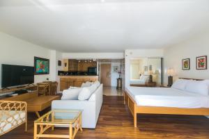 um quarto de hotel com uma cama grande e uma sala de estar em Ilikai Tower 1228 Lagoon View 1BR em Honolulu