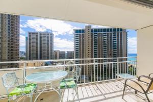 a balcony with a table and chairs and a view of the city at Ilikai Tower 1228 in Honolulu