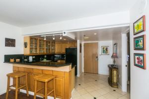 a kitchen with a black counter and a black refrigerator at Ilikai Tower 1228 in Honolulu +22 photos