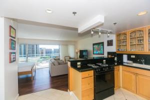 uma cozinha com um fogão e uma sala de estar em Ilikai Tower 1228 Lagoon View 1BR em Honolulu