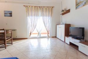 a living room with a tv and a large window at Spacious and bright apartment- Silvio 1 in Banjole