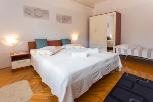 a bedroom with a large white bed and a mirror at Spacious and bright apartment- Silvio 1 in Banjole
