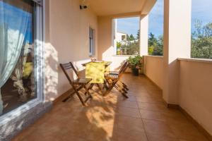 a balcony with two chairs and a table on it at Spacious and bright apartment- Silvio 1 in Banjole