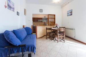 a living room with a blue couch and a table at Spacious and bright apartment- Silvio 1 in Banjole