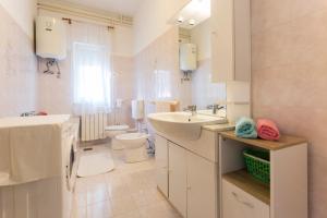 a white bathroom with a sink and a toilet at Spacious and bright apartment- Silvio 1 in Banjole +13 photos