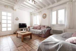 ein Wohnzimmer mit Sofa und Tisch in der Unterkunft La villa des mouettes in Biscarrosse