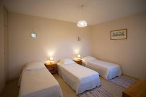 Zimmer mit 3 Betten und 2 Tischen mit Beleuchtung in der Unterkunft La villa des mouettes in Biscarrosse