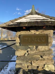 un panneau indiquant les rochers sur un bâtiment en pierre dans l'établissement Experience the Rocks Estate like never before with a stay at the Gardeners Cottage!, à Bethlehem