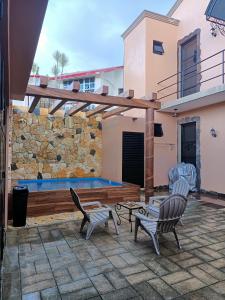 a patio with two chairs and a swimming pool at Casa Sandy in Cozumel