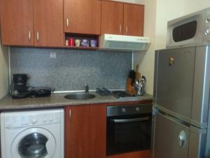 a kitchen with a sink and a stove and a dishwasher at TO FOUR+2 PREDELA 1 in Bansko