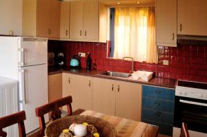 uma cozinha com uma mesa e um frigorífico branco em Alkionides Villas em Xerokampos