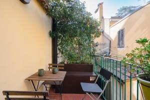 um pátio com uma mesa e cadeiras numa varanda em Casa Santa Caterina em Bolonha