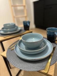 una mesa con tazones azules y platos en una mesa en Studio Puebla, en Périgueux