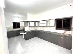 an empty kitchen with gray cabinets and windows at ENTIRE HOUSE at KOLLAM DISTRICT in Kottiyam