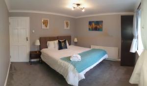 een slaapkamer met een bed met een handdoek erop bij Pinewood Studios, Iver near Heathrow and Windsor XL 75sqm 2 King Bed Flat with 2 Parking Spaces in Buckinghamshire