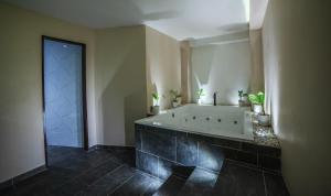 La salle de bains est pourvue d'une baignoire et d'un grand miroir. dans l'établissement HOTEL BALI AT POBLADO, à Medellín