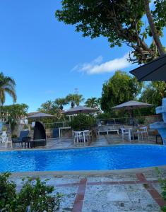 璜多里奧的住宿－迪芙蘭切斯旅館，一个带桌椅和遮阳伞的游泳池