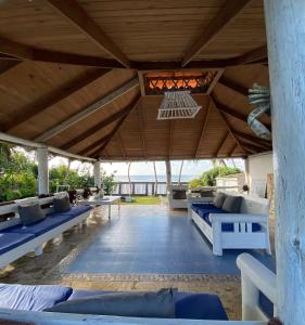 un patio al aire libre con sofás azules y techo de madera. en D' Franchesis Hostal en Juan Dolio