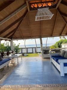 een paviljoen met bedden en tafels en uitzicht op de oceaan bij D' Franchesis Hostal in Juan Dolio