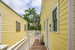 a yellow house with a porch and a window at NEW VanGogh Studio by Brightwild- Pool & Balconies in Key West