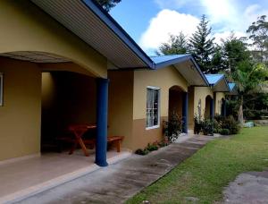 una casa gialla con un tavolo da picnic in un cortile di cabanas las molas a Volcán