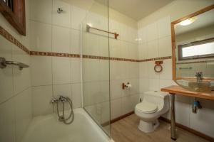 een badkamer met een bad, een toilet en een wastafel bij Cabañas Sierra Nevada in Malalcahuello