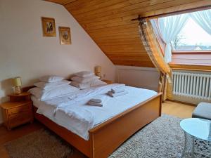a bedroom with a bed with white sheets and a window at Vila Gabriel in Nová Lesná