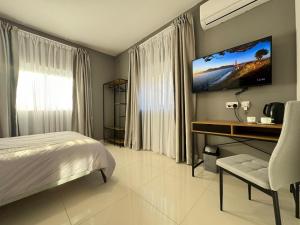 a bedroom with a bed and a television on the wall at BaySide1 Marsaxlokk Malta in Marsaxlokk