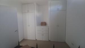 a white closet with white cabinets and a box at Departamento BENSO in Paso de los Libres